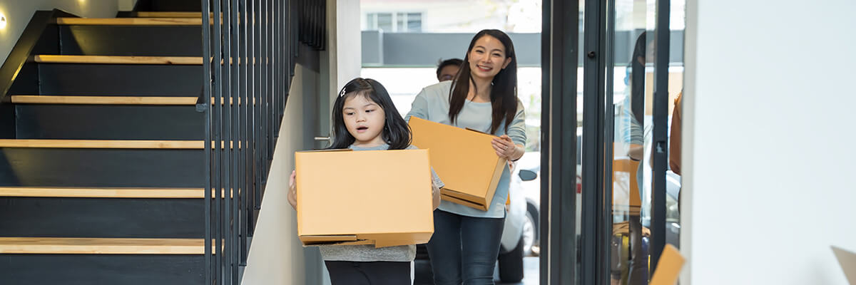 Young Couple and child move boxes into new home.